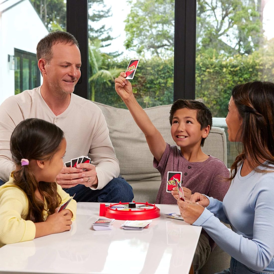 A family playing Uno Spin around a coffee table